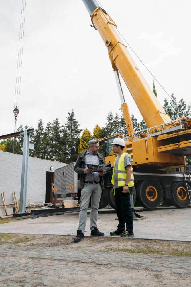 Deux personnes devant une grue mobile